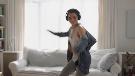 happy-young-woman-dancing-at-home-having-fun-listening-to-music-wearing-headphones-enjoying-weekend-celebration-with-funky-dance-moves