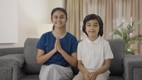 Happy-Indian-siblings-doing-Namaste-to-the-camera