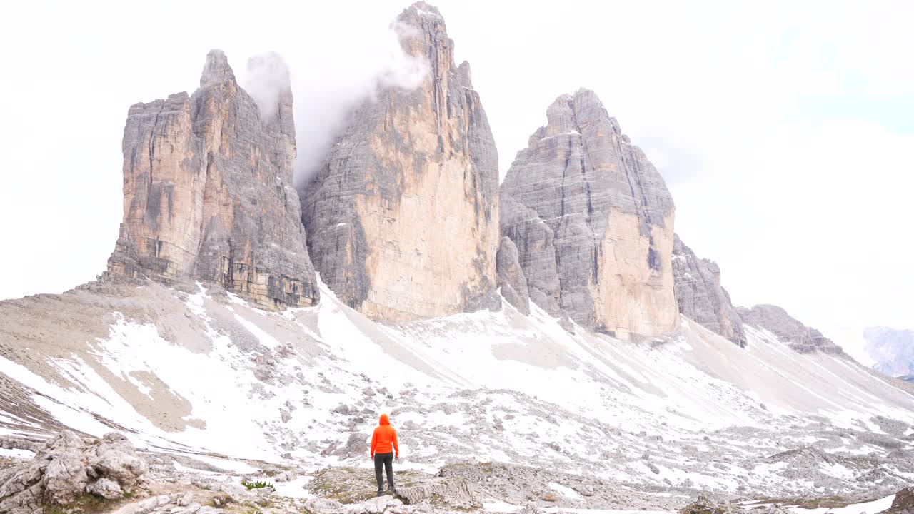 logro personal de un hombre admirando los majestuosos tres picos de cime di lavaredo