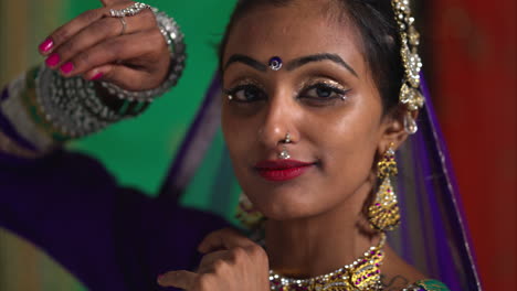 cabeza y hombros toma de estudio de una mujer sonriente bailarina de kathak realizando un baile vestida con un vestido tradicional indio 5