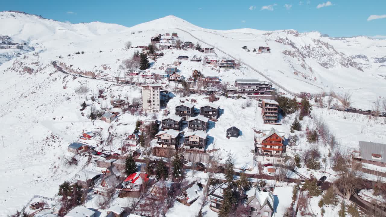 칠레 산티아고 근처 의 겨울 에 파 ⁇ 로네스 스키 리조트 의 산 마을 위 에 있는 오두막