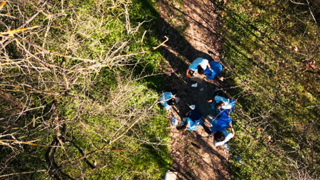 Toma-De-Drone-Del-Equipo-De-Activistas-Limpiando-Y-Reciclando-Basura-En-Un-Bosque.