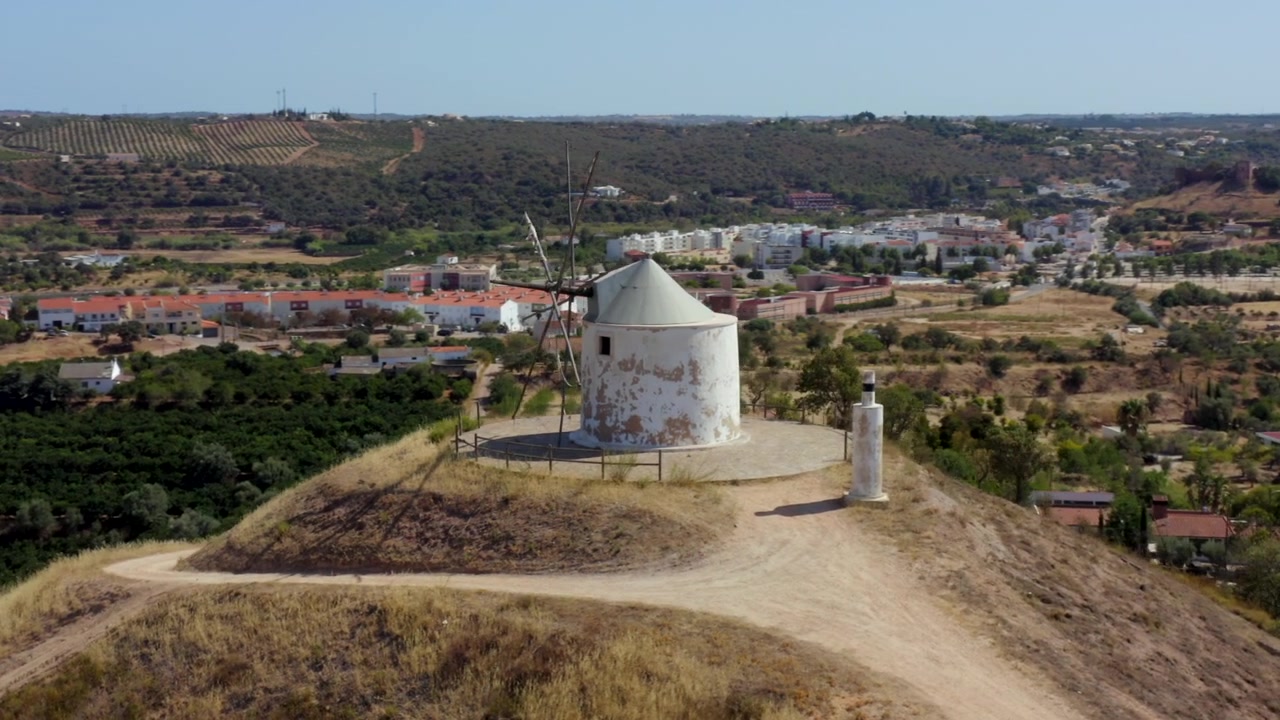 Portekiz Algarve'deki Silves Şehri'ne bakan tepe üstü eski terk edilmiş yel değirmeni. Havadan drone çekimi