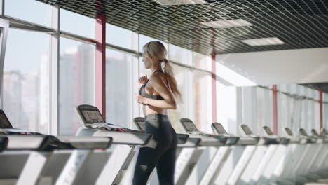 Fitness-woman-running-on-treadmill-in-gym.-Pretty-girl-having-cardio-training.