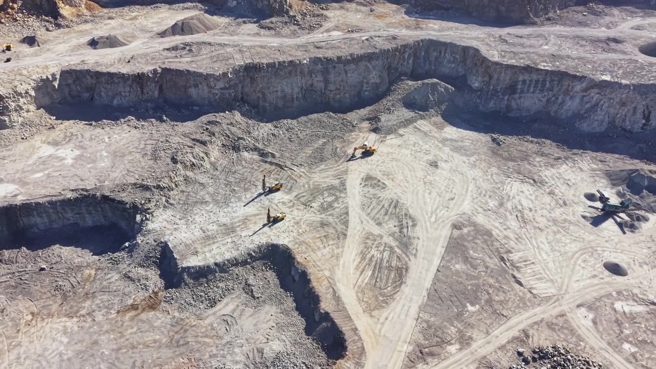 Granite quarry with heavy machinery working on the site during daylight hours