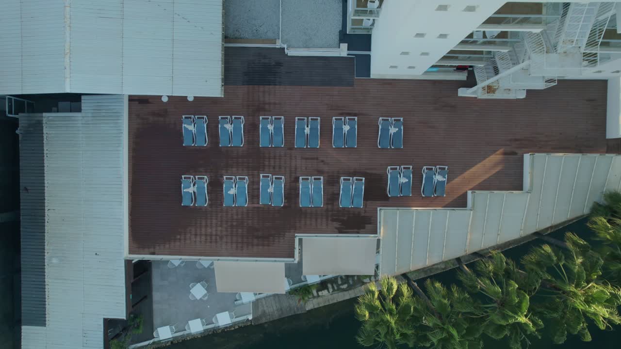 imagen aérea de la terraza del complejo con sillas de sol y palmeras con vista a la costa del mar mediterráneo en palma de mallorca, españa