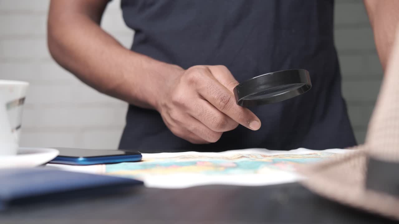 Person Looking at a Map with a Magnifying Glass