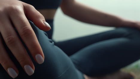 Fit-woman-keep-hands-on-knees-meditating-on-seashore.-Girl-practicing-yoga.