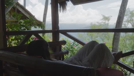 chica relajada acostada en un hotel tropical con vistas al mar