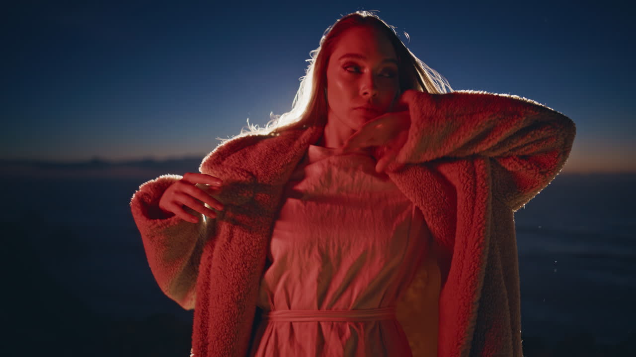 Party woman dancing neon light beach at night closeup. Fashionista moving sunset