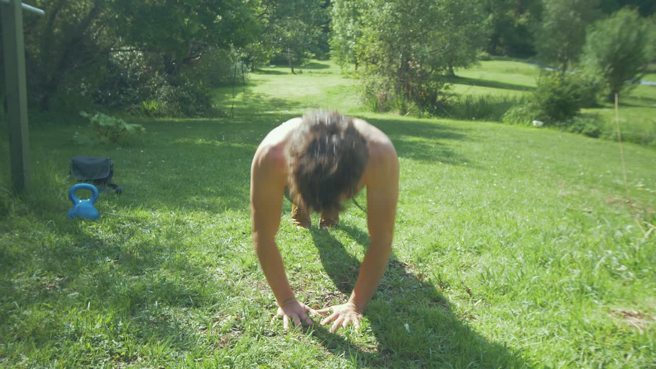 un joven atlético haciendo flexiones de diamante en el jardín