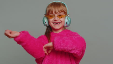 Happy-preteen-child-girl-kid-listening-music-via-headphones-and-dancing-disco-fooling-around