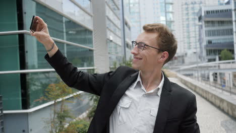 Hombre-Caucásico-Sonriente-Haciendo-Selfie-En-El-Teléfono-Afuera