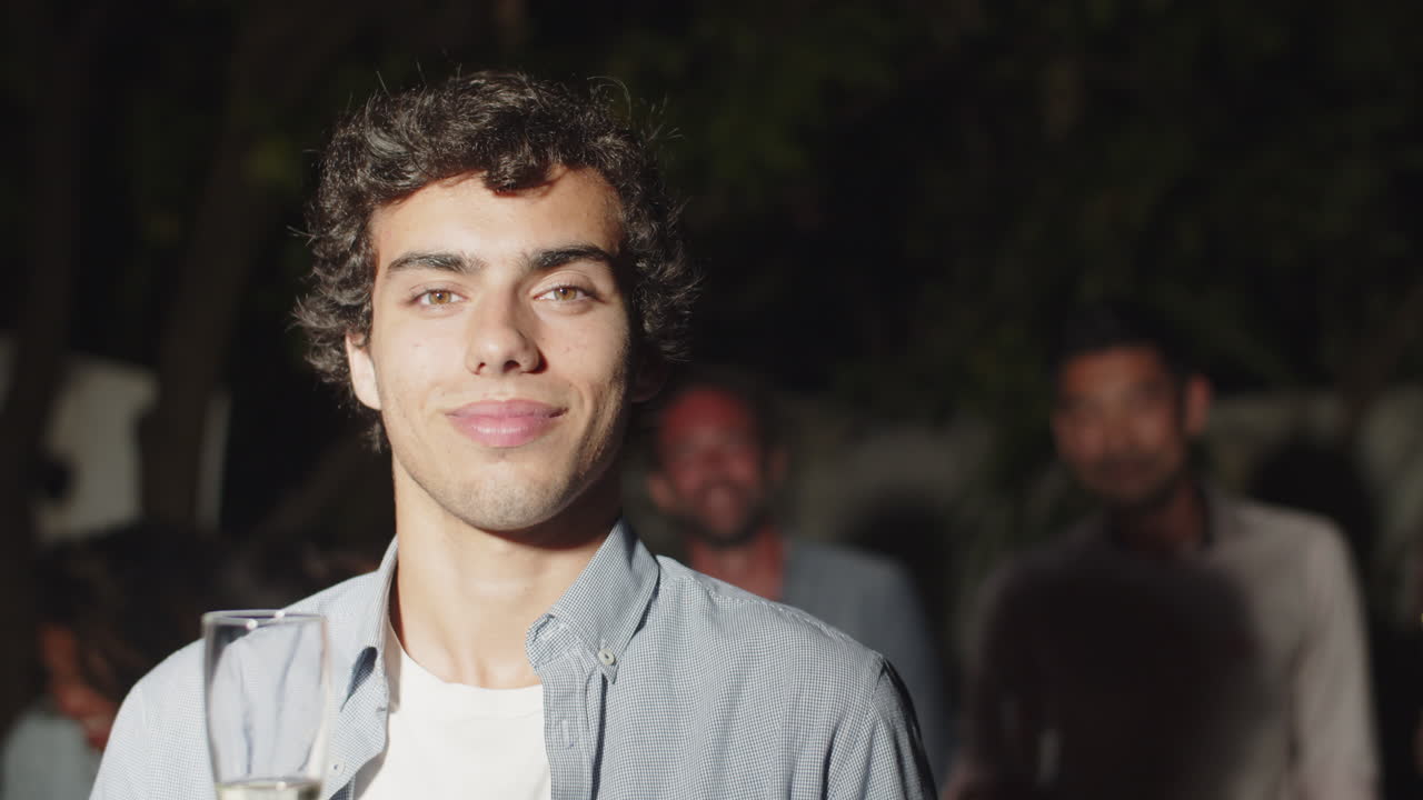 Bel ragazzo che si rilassa a una festa e guarda la telecamera