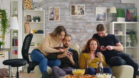 group of friends sitting on couch using their smartphones