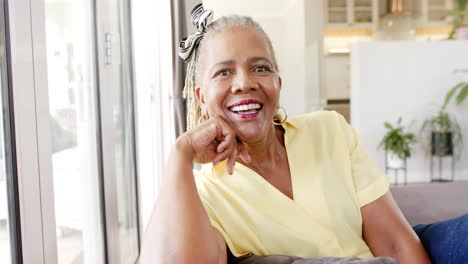 a senior african american woman with bright smile sitting indoors