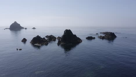 calm water and misty coastal rock islets of south ireland's celtic sea