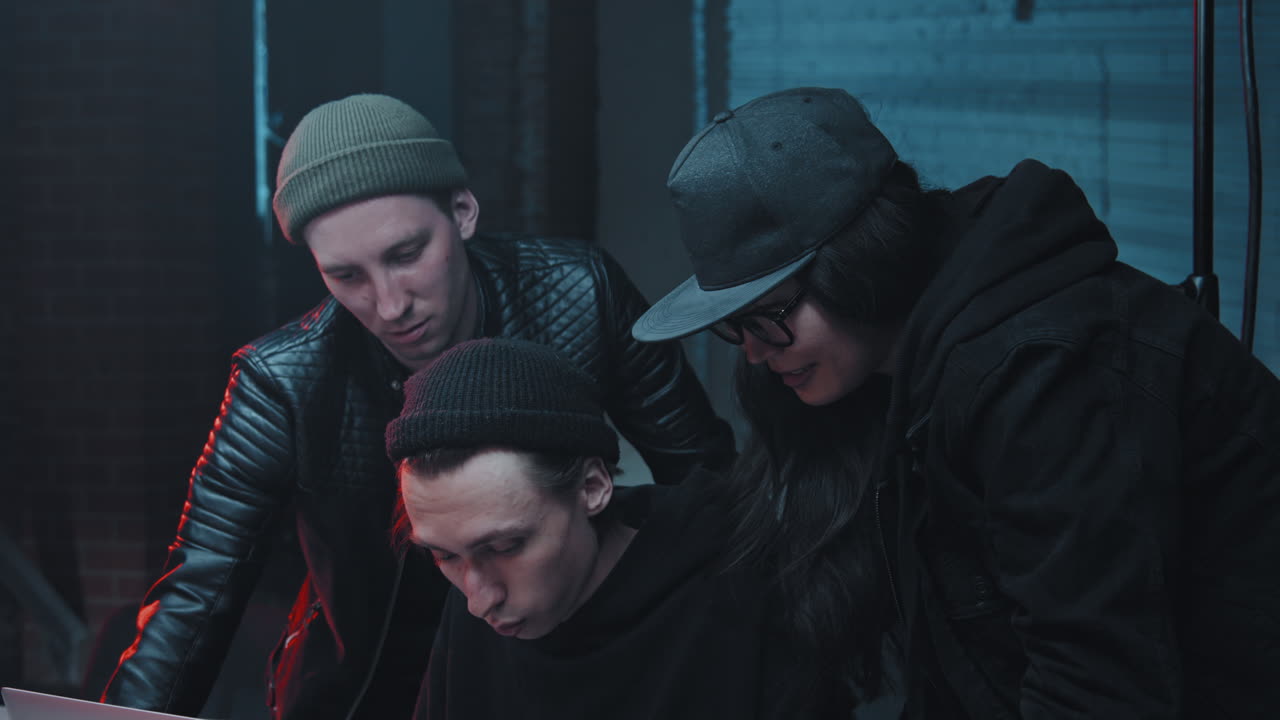 Hackers Coding on Laptop in Dark Office