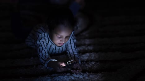 child using smartphone in the dark