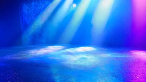 a large room with a blue, red, and purple light shining on the floor. the room is empty and the light is creating a colorful and vibrant atmosphere