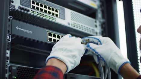 a technician expertly connects network cables in a data center, ensuring seamless electrical connections in a server rack equipped with high-performance switches and routers