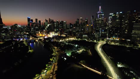 sun setting on an illuminated highway leading towards melbourne cbd