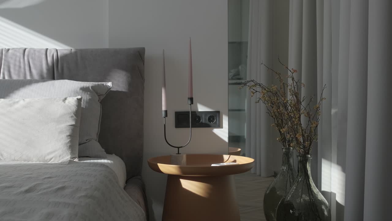 diseño y decoración de interiores de dormitorios modernos con sábanas blancas y grises, silla blanca, cabecera de luz nocturna.