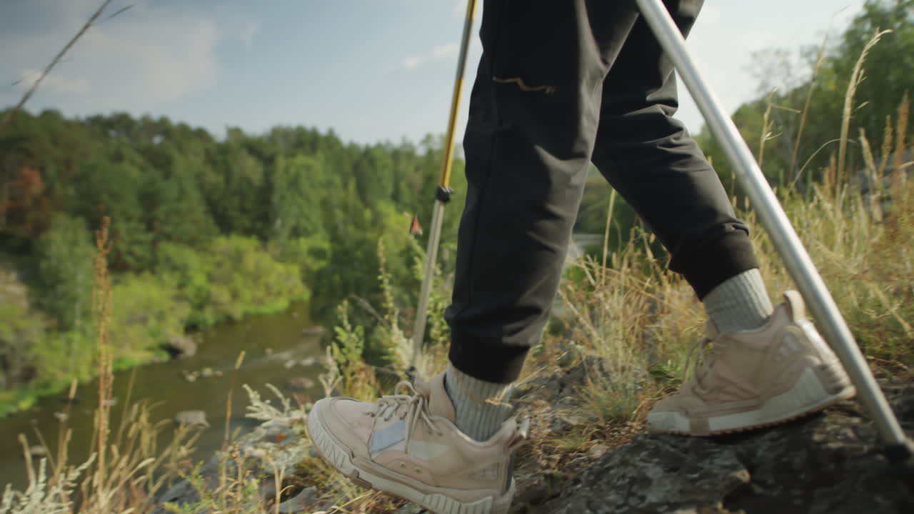 Legs of Female Tourist Trekking on Mountain Trail