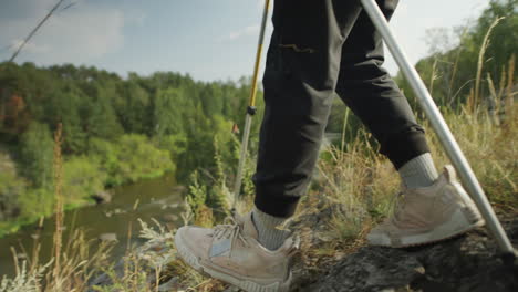 legs of female tourist trekking on mountain trail