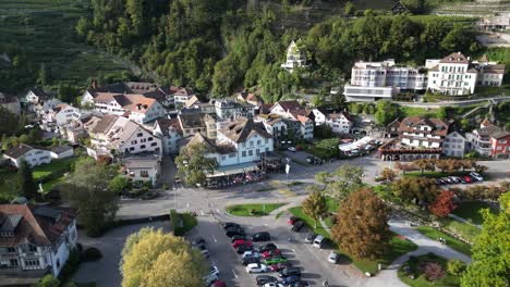 aerial clip of a town with compact houses situated near a forested mountain area