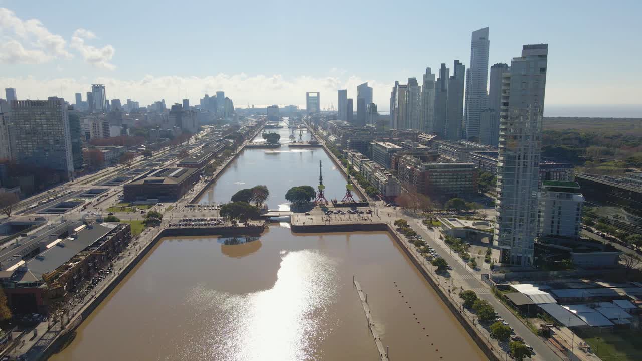 오른쪽에 일부 고층건물이 있는 푸에르토 마데로의 수로 위로 날아가는 조감도