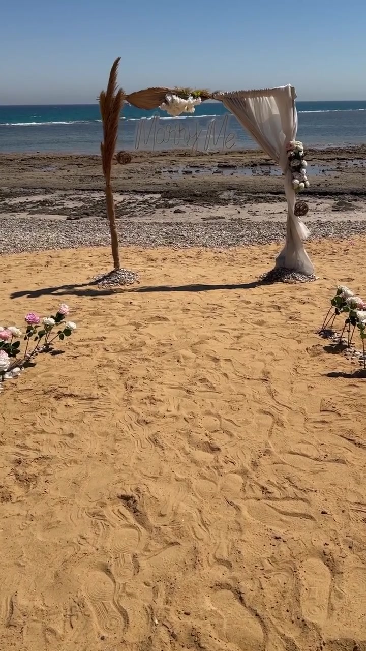 Beach wedding setup with a rustic floral arch overlooking the sea, close up hot