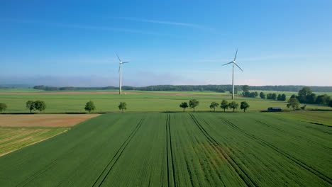 Aerial-drone-over-farmlands-with-windmills-in-background