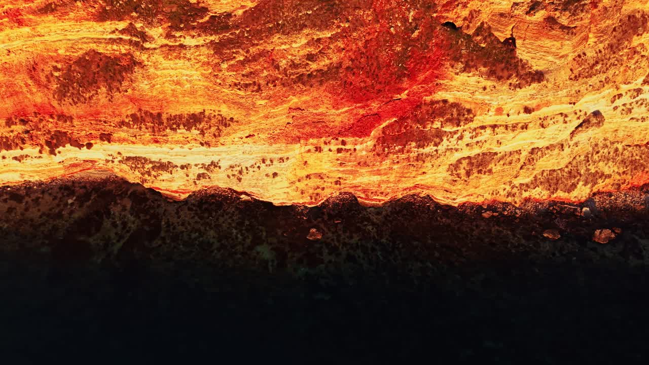 Colate laviche ricoprono un terreno roccioso durante il tramonto in un paesaggio vulcanico