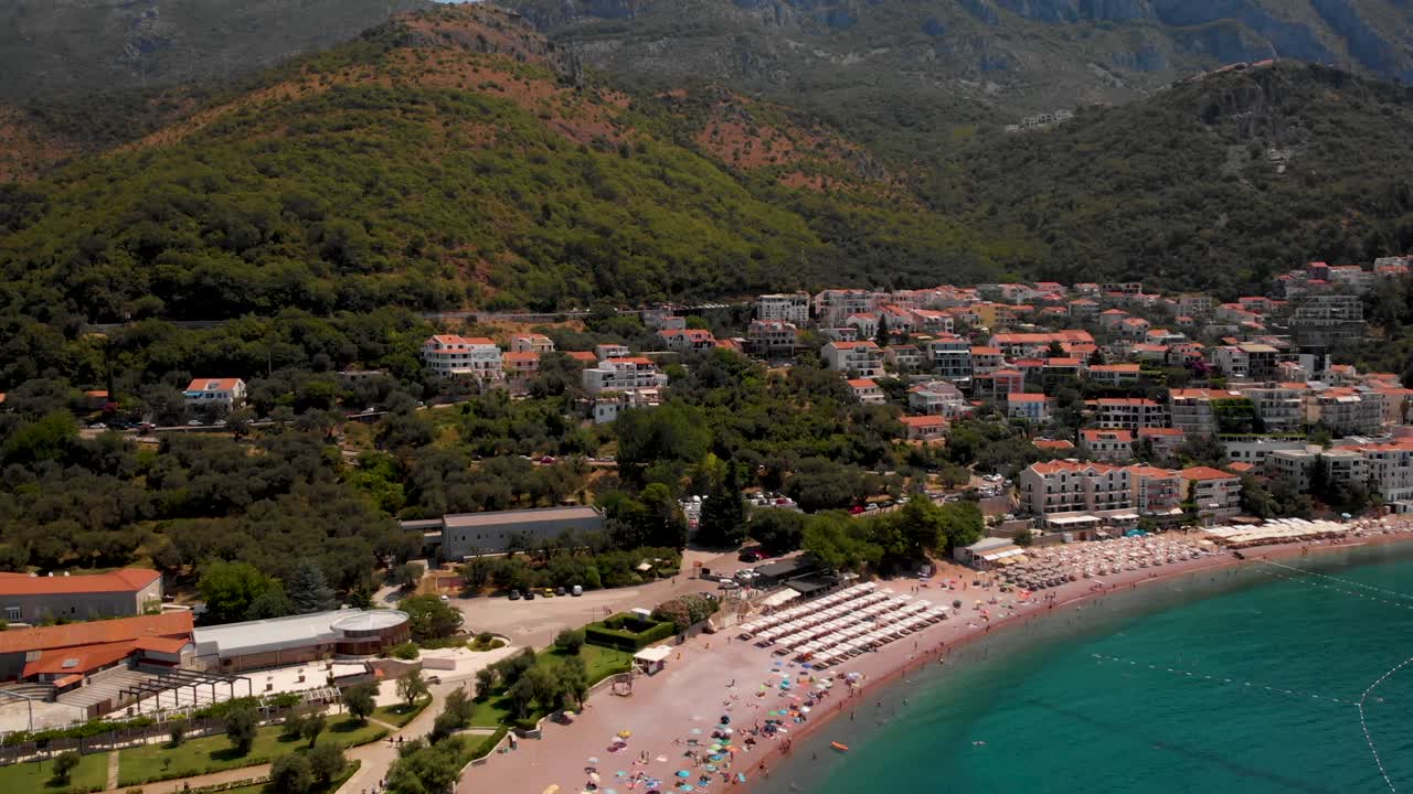 Stunning View Of Tourists Spending Vacation On A Beach In Sveti Stefan Island During Summer In Montenegro