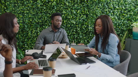 Afroamerikanische-Geschäftsleute-Treffen-Schwangere-Teamleiterin,-Die-Einen-Tablet-Computer-Nutzt,-Um-Das-Design-Mobiler-Anwendungen-Zu-Präsentieren-Und-Kreative-Ideen-Für-Die-Kommunikations-App-In-Einer-Büropräsentation-Auszutauschen