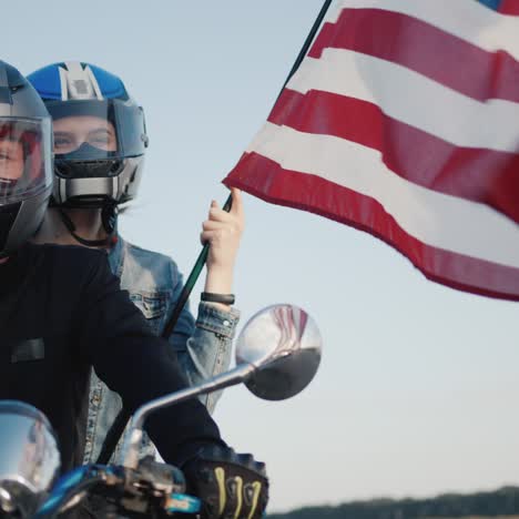 Biker-with-girlfriend-sits-on-motorcycle