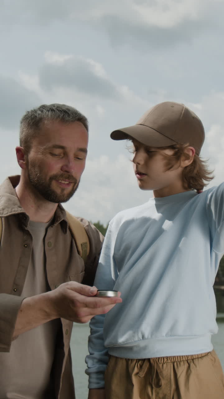 Father and Son Exploring Outdoors with Compass