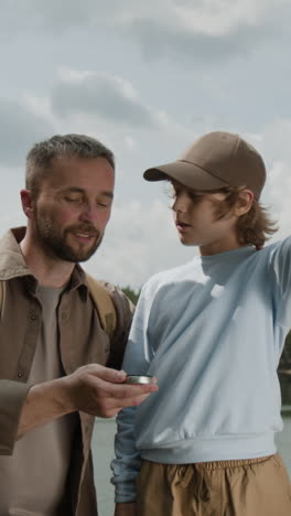 father and son exploring outdoors with compass