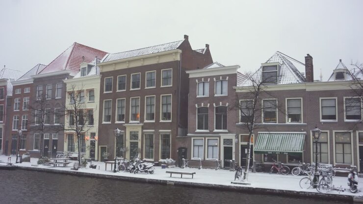Leiden city buildings in winter snow on Rijn riverside, Netherlands, panoramic