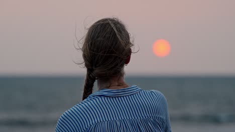 a serene moment in galle, sri lanka, as a woman gazes at the vast ocean during a breathtaking sunset.