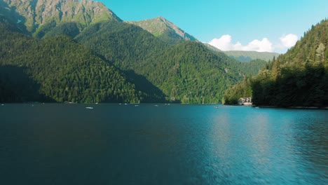 mountain lake with boats and lush forest