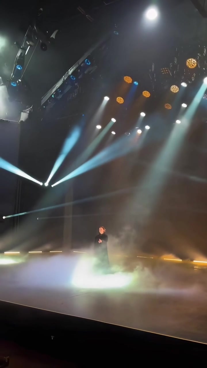 Singer Performing on Stage with Dramatic Lighting and Fog