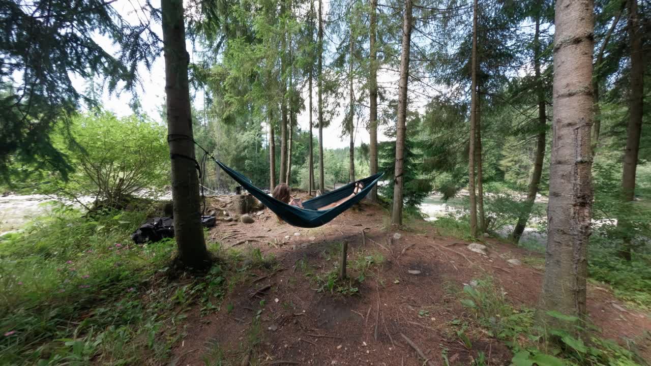 Coffee moment in hammock surrounded by pine trees and sunlight