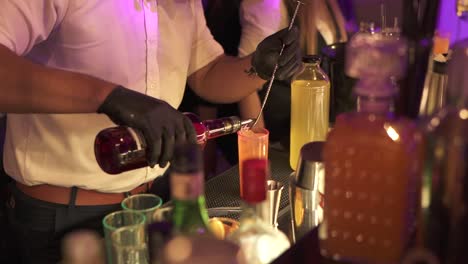 bartender pouring ingredients preparing tequila sunrise cocktail