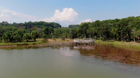 4k aerial panoramic view over the clear waters of the laguna de los milagros in tingo maria, peru