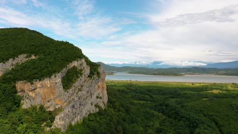 Lush-Rocky-Cliff-Near-The-Calm-Shaori-Lake-In-Racha,-Georgia---aerial