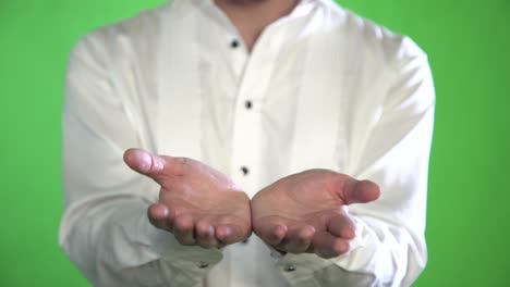 closeup of the palm of a man in a shirt on a green background