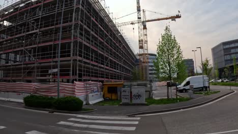 construction site of commercial building with industrial cranes in italy