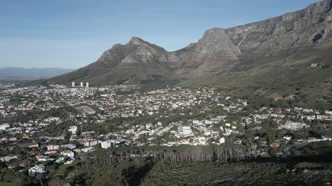 Drone shot looking over Cape Town's sprawling neighborhoods with Devil's Peak looming in the distance